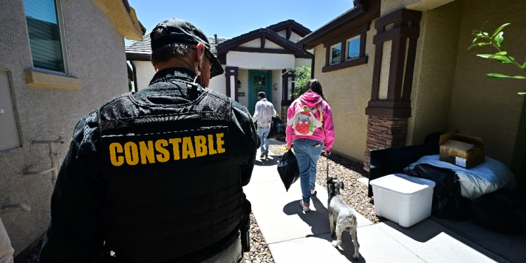 Lennie McCloskey, Constable of Manistee Justice Precint in Maricopa County watches as a family who has just been evicted carry out their belongings on April 15, 2024 in Phoenix, Arizona / ©AFP