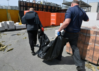 Utility workers carry a bodybag as they evacuate the remains of a victim who was killed in a hardware supermarket in Kharkiv destroyed by a Russian strike, on May 26, 2024, amid the Russian invasion of Ukraine. . ©AFP