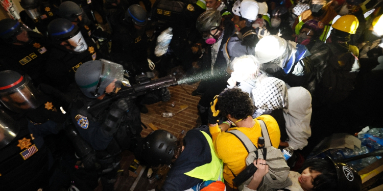 Police clash with pro-Palestinian students after destroying part of the encampment barricade at the University of California, Los Angeles (UCLA) early on May 2, 2024 / ©AFP