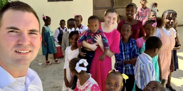 US missionaries Davy and Natalie Lloyd who were killed in Haiti on May 23, 2024, pose with Haitian children in an undated photo. ©AFP