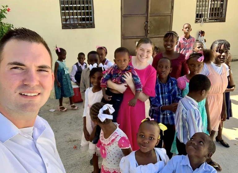 US missionaries Davy and Natalie Lloyd who were killed in Haiti on May 23, 2024, pose with Haitian children in an undated photo. ©AFP