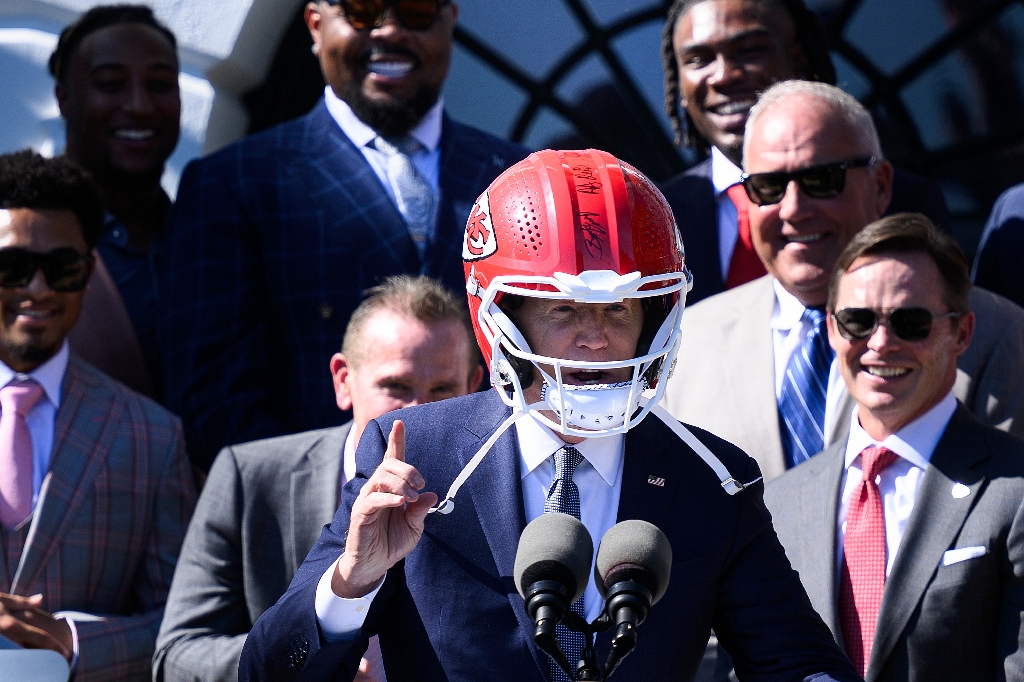 US President Joe Biden wears a Kansas City Chiefs helmet while speaking during a celebration for the Kansas City Chiefs, 2024 Super Bowl champions, on the South Lawn of the White House in Washington, DC, on May 31, 2024. / ©AFP