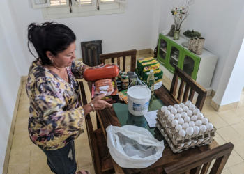 Maria Paez unpacks a box of food items sent from her children in Miami to Havana. ©AFP