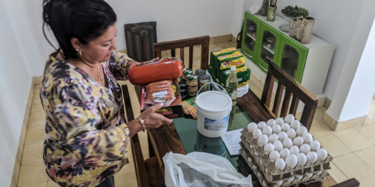 Maria Paez unpacks a box of food items sent from her children in Miami to Havana. ©AFP