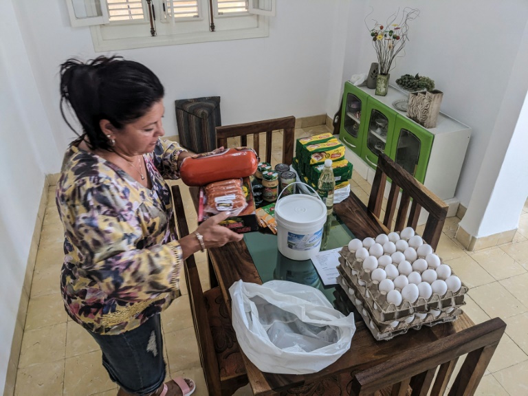 Maria Paez unpacks a box of food items sent from her children in Miami to Havana. ©AFP