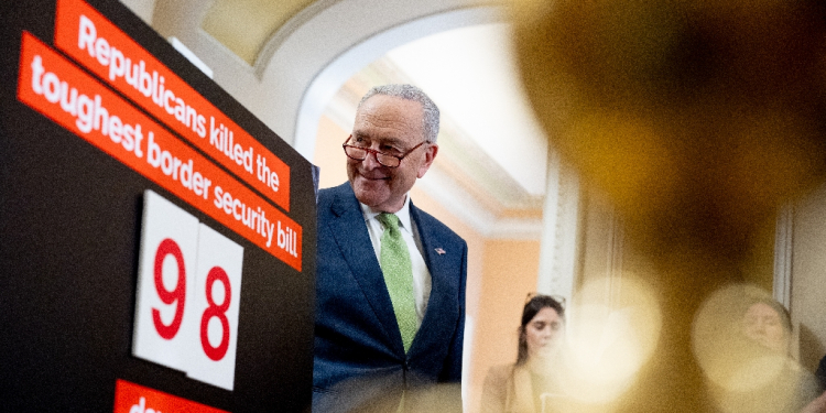 Senate Majority Leader Chuck Schumer stands next to a poster that reads Republicans killed the toughest border security bill 98 days ago. Democrats are ready to act  / ©AFP