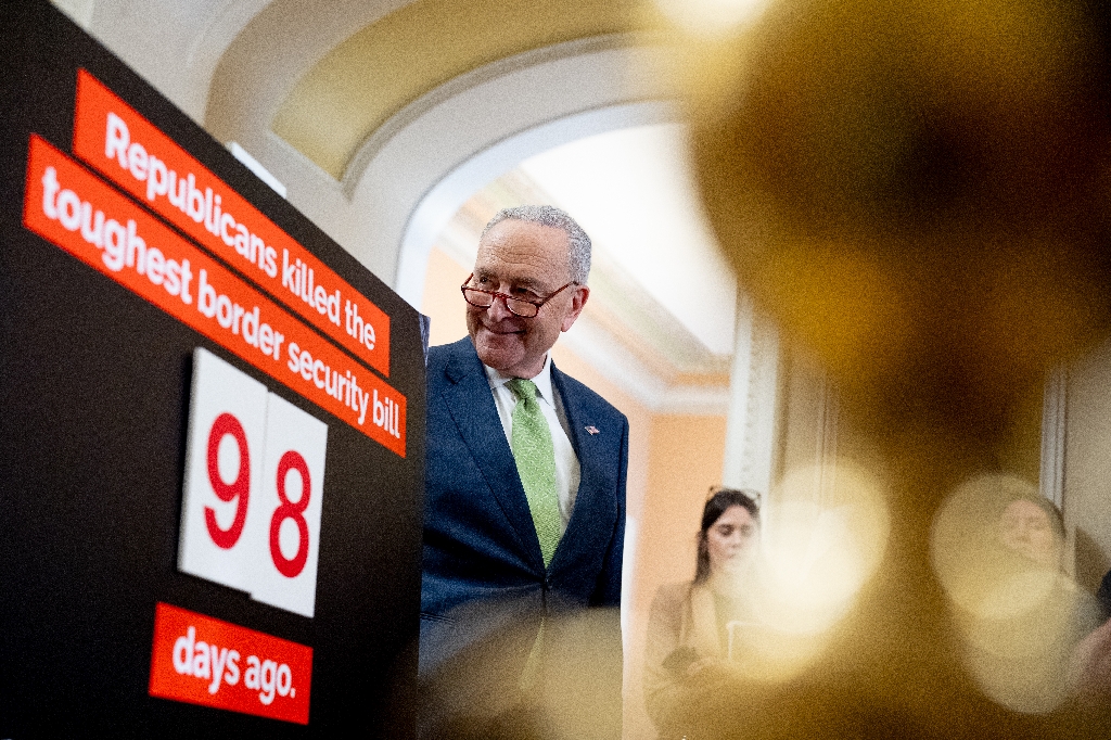 Senate Majority Leader Chuck Schumer stands next to a poster that reads Republicans killed the toughest border security bill 98 days ago. Democrats are ready to act  / ©AFP