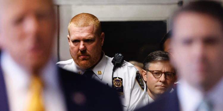 US Speaker of the House Mike Johnson (second R) listens as former president Donald Trump (L) speaks to reporters beforing entering his trial over allegedly covering up hush money payments  / ©AFP