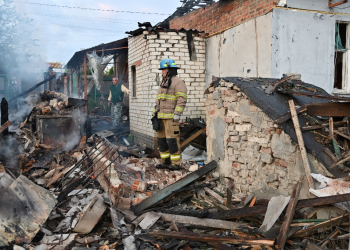 Firefighters clear debris from private houses in the suburbs of Kharkiv  / ©AFP