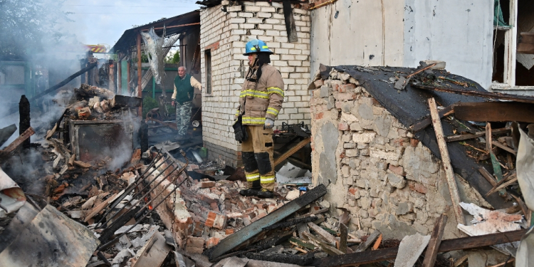 Firefighters clear debris from private houses in the suburbs of Kharkiv  / ©AFP