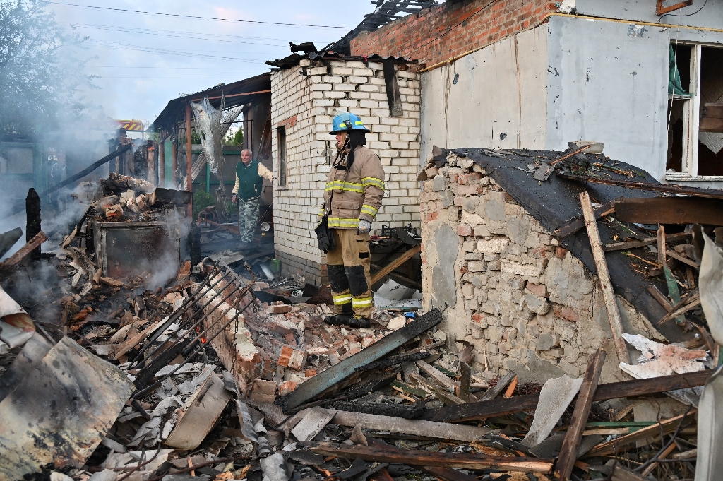 Firefighters clear debris from private houses in the suburbs of Kharkiv  / ©AFP