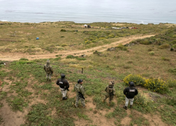 Mexican officers stand guard as rescue and forensics workers as well as prosecutors work at a waterhole where human remains were found near La Bocana Beach, Santo Tomas. ©AFP