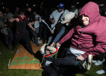 A pro-Palestinian demonstrator (C) is beaten by counter protesters at a pro-Palestinian encampment set up on the UCLA campus in Los Angeles  / ©AFP