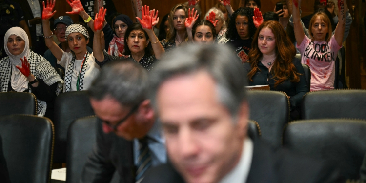 Pro-Palestinian demonstrators hold up painted hands in protest as US Secretary of State Antony Blinken testifies before a Senate Appropriations subcommittee  / ©AFP