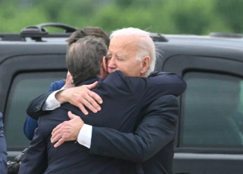 US President Joe Biden (R) hugs his son Hunter Biden upon arrival in Delaware after the younger Biden's conviction on felony gun charges / ©AFP