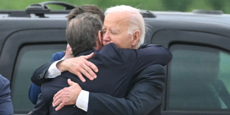 US President Joe Biden (R) hugs his son Hunter Biden upon arrival in Delaware after the younger Biden's conviction on felony gun charges / ©AFP