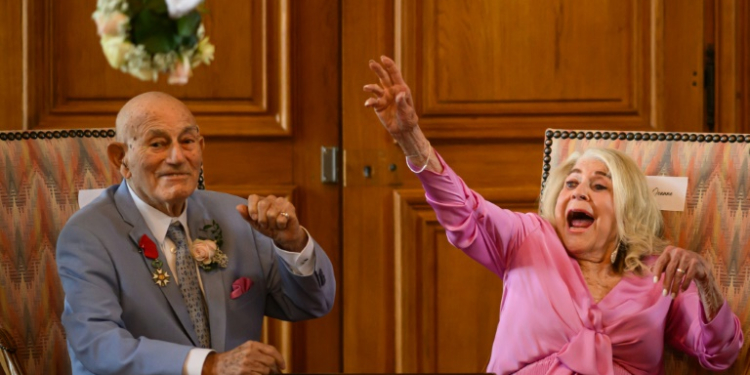 Jeanne Swerlin, 96, throws her bouquet of flowers after officialising her marriage to US WWII veteran Harold Terens, 100, in the town hall of Carentan-les-Marais, in Normandy. ©AFP