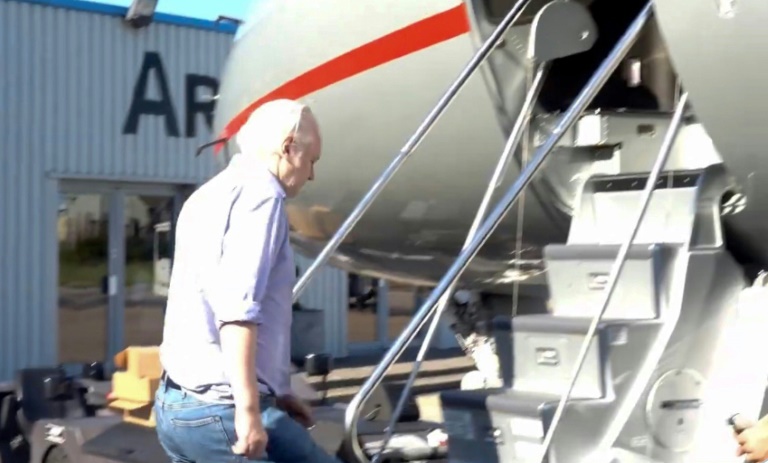 Wikileaks founder Julian Assange walking to board a plane from London, released from a high-security prison where he was held for five years. ©AFP