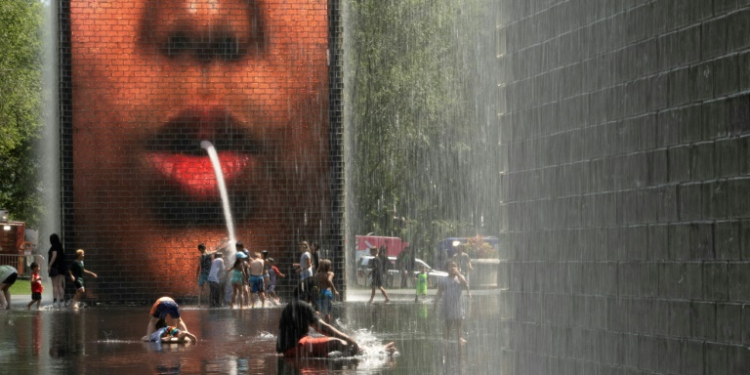 People cool off at Crown Fountain in Chicago's Millennium Park, as temperatures soar and officials warn of extreme heat. ©AFP