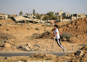 An amputee makes his way past buildings destroyed during Israeli bombardment, at al-Bureij refugee camp, central Gaza  / ©AFP