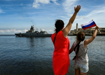 Cubans wave as Russian ships leave the Havana harbor after a five-day visit. ©AFP