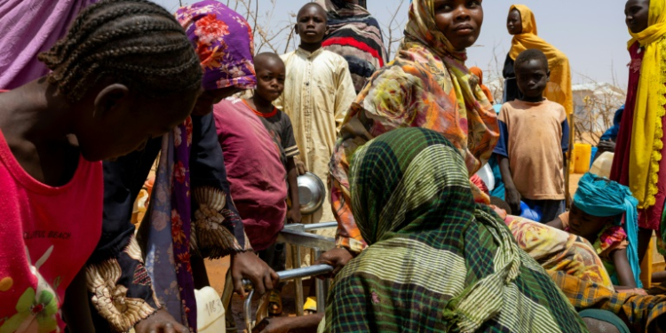 Sudanese refugees gather to fill cans with water in the Farchana refugee camp in Chad on April 8, 2024. ©AFP