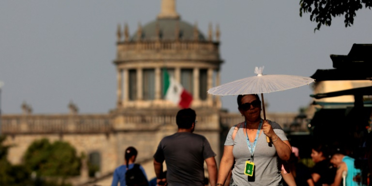 People protect themselves from the sun during a heat wave hitting the country, in Guadalajara, Jalisco state, Mexico, in May 2024. ©AFP