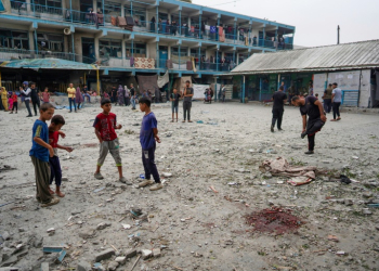 Palestinian boys stand near blood stains at a UN school housing displaced people that was hit during Israeli bombardment in Nuseirat in the central Gaza Strip. ©AFP