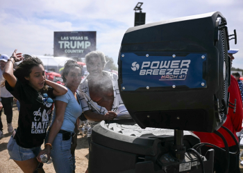 Donald Trump supporters cool off as they attend the Republican candidate's rally in Las Vegas on June 9, 2024 / ©AFP