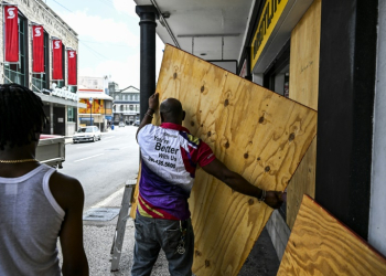 A man prepares to board up a shop window as people prepare for the arrival of Hurricane Beryl in Bridgetown, Barbados. ©AFP