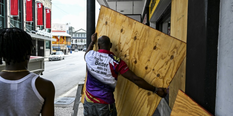 A man prepares to board up a shop window as people prepare for the arrival of Hurricane Beryl in Bridgetown, Barbados. ©AFP