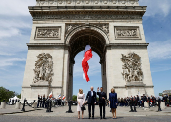 France's President Emmanuel Macron welcomes Joe Biden at a ceremony at the Arc de Triomphe in Paris. ©AFP