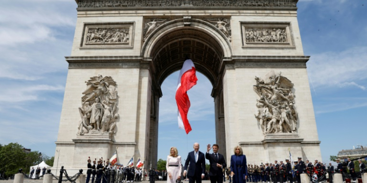 France's President Emmanuel Macron welcomes Joe Biden at a ceremony at the Arc de Triomphe in Paris. ©AFP