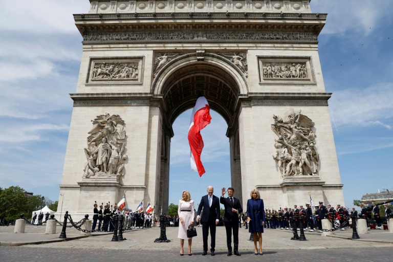 France's President Emmanuel Macron welcomes Joe Biden at a ceremony at the Arc de Triomphe in Paris. ©AFP