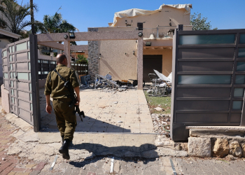 An Israeli soldier checks a house that was hit by a Hezbollah rocket in Kiryat Shmona, northern Israel, near the Lebanon border / ©AFP