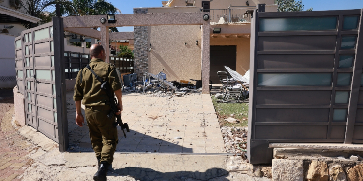 An Israeli soldier checks a house that was hit by a Hezbollah rocket in Kiryat Shmona, northern Israel, near the Lebanon border / ©AFP