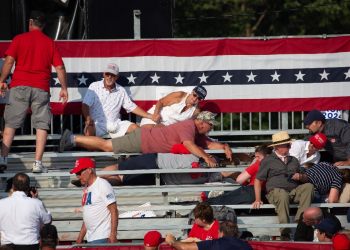 Trump supporters are seen laying in the stands after shots were fired at Republican candidate Donald Trump at a campaign event in Butler, Pennsylvania / ©AFP