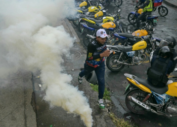 A demonstrator runs away from teargas during a protest against Venezuelan President Nicolas Maduro after he claimed victory in Sunday's election . ©AFP