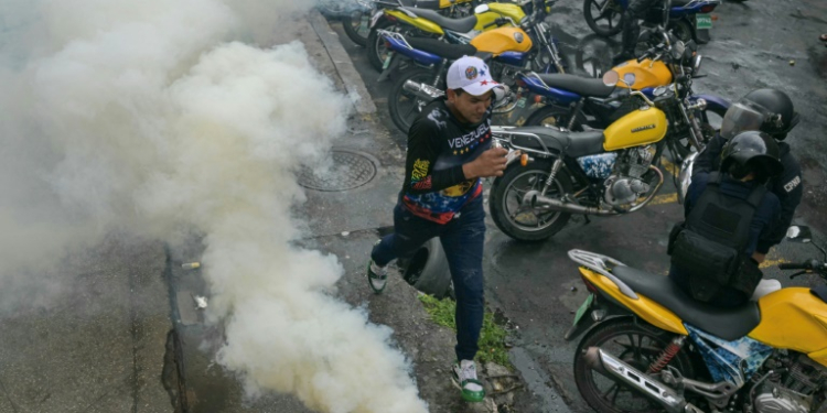 A demonstrator runs away from teargas during a protest against Venezuelan President Nicolas Maduro after he claimed victory in Sunday's election . ©AFP