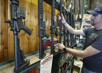 Dordon Brack pulls a semi-automatic AR-15 off the rack at Good Guys Guns & Range on February 15, 2018 in Orem, Utah. ©AFP