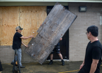 A group of men board up a restaurant in Port Lavaca, Texas, on July 7, 2024, as they prepare for the arrival of tropical storm Beryl. ©AFP