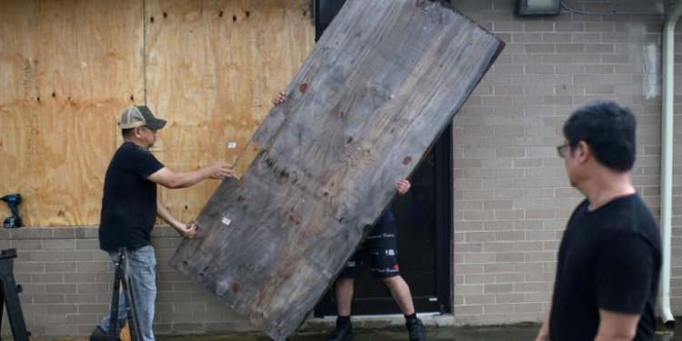 A group of men board up a restaurant in Port Lavaca, Texas, on July 7, 2024, as they prepare for the arrival of tropical storm Beryl. ©AFP