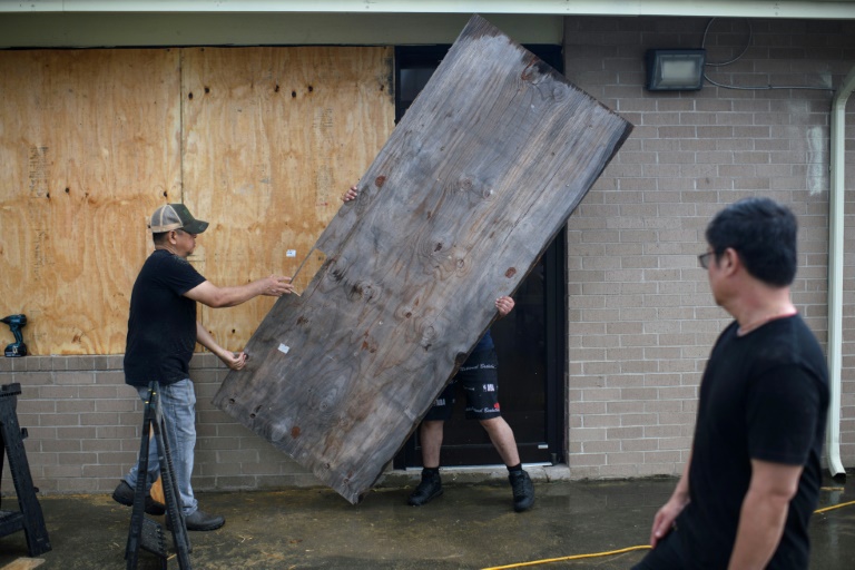 A group of men board up a restaurant in Port Lavaca, Texas, on July 7, 2024, as they prepare for the arrival of tropical storm Beryl. ©AFP