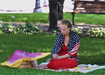 A person prays in a park in downtown Milwaukee, Wisconsin, on July 14, 2024 ahead of the Republican presidential convention / ©AFP