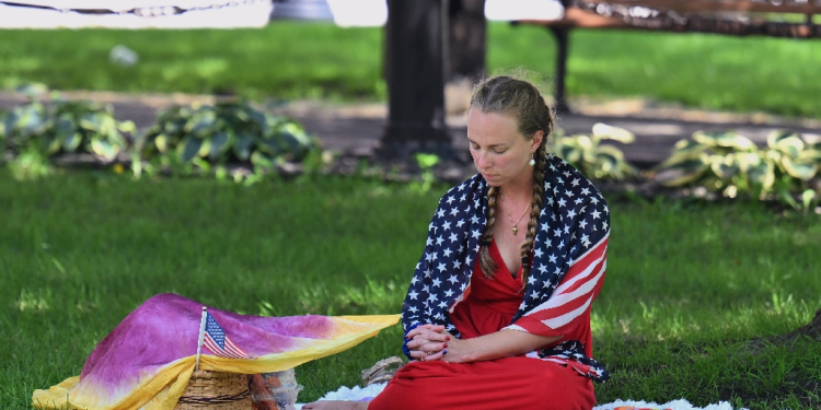 A person prays in a park in downtown Milwaukee, Wisconsin, on July 14, 2024 ahead of the Republican presidential convention / ©AFP