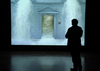 A journalist watches Bill Viola's video 'The Deluge' during a press preview of a 2017 exhibition at the Palazzo Strozzi in Florence. ©AFP