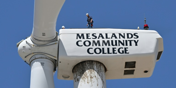 Wind turbine technician Terrill Stowe stands on the nacelle, which houses the gearbox and generator, atop the tower of a wind turbine on the campus of Mesalands Community College in the former Route 66 town of Tucumcari, New Mexico. ©AFP