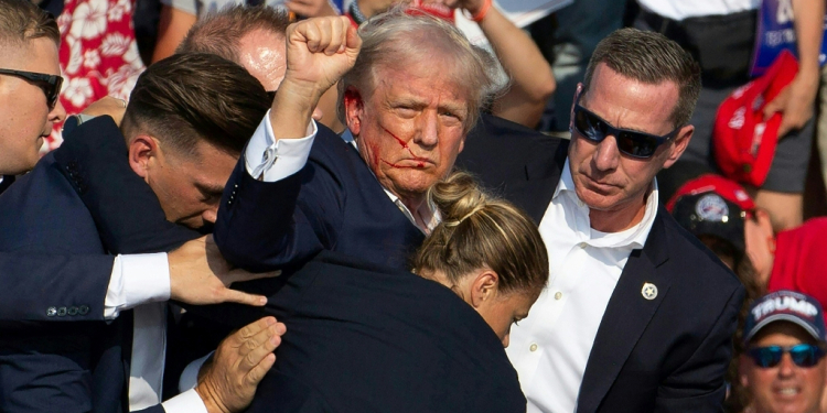 Republican candidate Donald Trump is seen with blood on his face surrounded by secret service agents as he is taken off the stage at a campaign event in Butler, Pennsylvania, July 13, 2024 / ©AFP