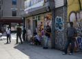 People stand outside a corner store during a summer heat wave in the Bronx borough of New York on July 11, 2024. ©AFP