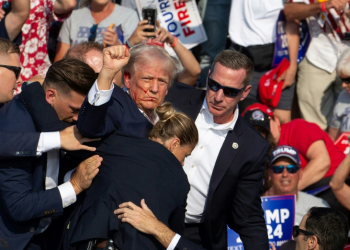 Republican candidate Donald Trump surrounded by Secret Service agents as he is taken off the stage. ©AFP